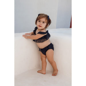 Bebê de 11 meses vestindo biquíni infantil de praia de renda azul marinho com babadinhos da Lili Sampedro