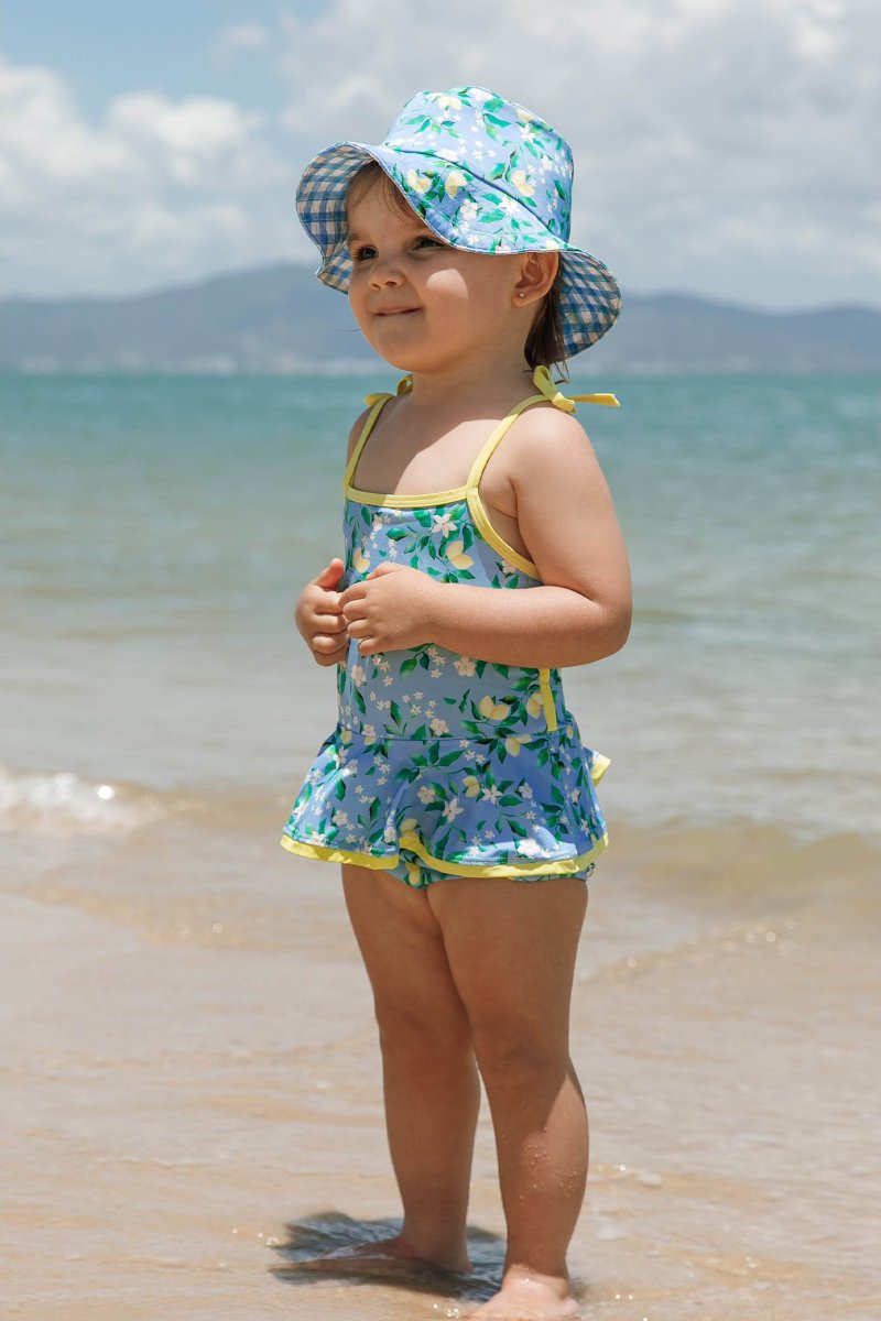Bebe de 2 anos de maiozinho e chapéuzinho de lycra na mesma estampa limoes da Lili Sampedro