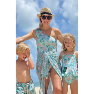 Camila Amaral (Mala de Mae) Vestindo Maio de Um Ombro Só na Estampa Coqueiros Tiffany combinando com os filhos na praia com Look da Lili Sampedro Moda Praia Família