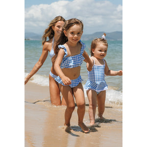 Meninas correndo na praia com look de praia combinando, uma de biquíni Vicky vestindo tamanho 6, e a outra com maiozinho olivia vestindo tamanho 2