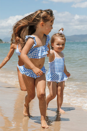 Meninas correndo na praia combinando com biquíni e maio infantil feminino na Estampa Vichy da Lili Sampedro combinando com a Mae