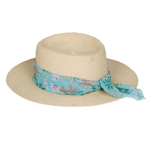 Lenço Estampado Coqueiros Tiffany amarrado em um chapéu de praia de palha da Lili Sampedro Moda Praia Família